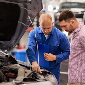 Mechanic Examining a Car with Car Owner